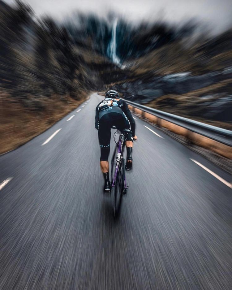 Um ciclista percorre uma estrada de montanha